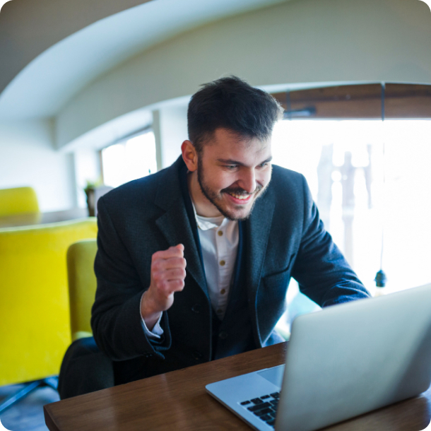 Business professional celebrating success while working on a laptop, representing customer success and innovation.