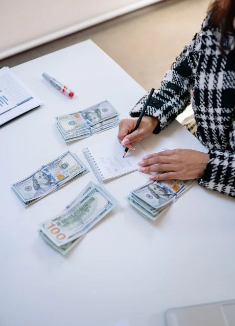 Person calculating financial figures while reviewing documents