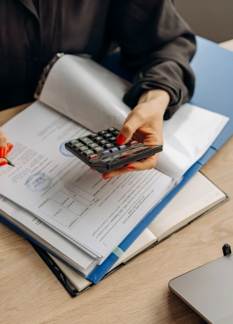 Person using a calculator while working with financial documents