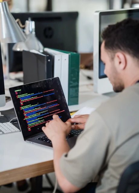 Developer working with software code on a laptop