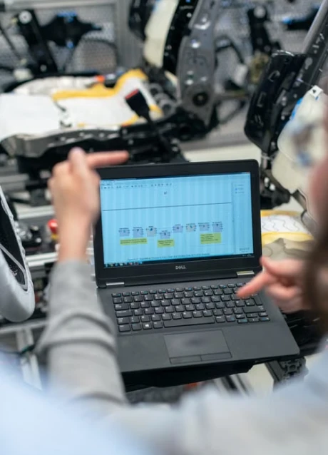 Manufacturing team using a laptop to coordinate production workflows