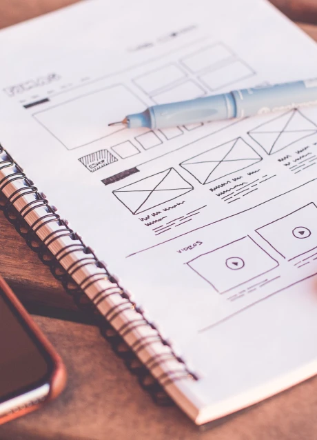 Hand-drawn software interface wireframes on a notebook