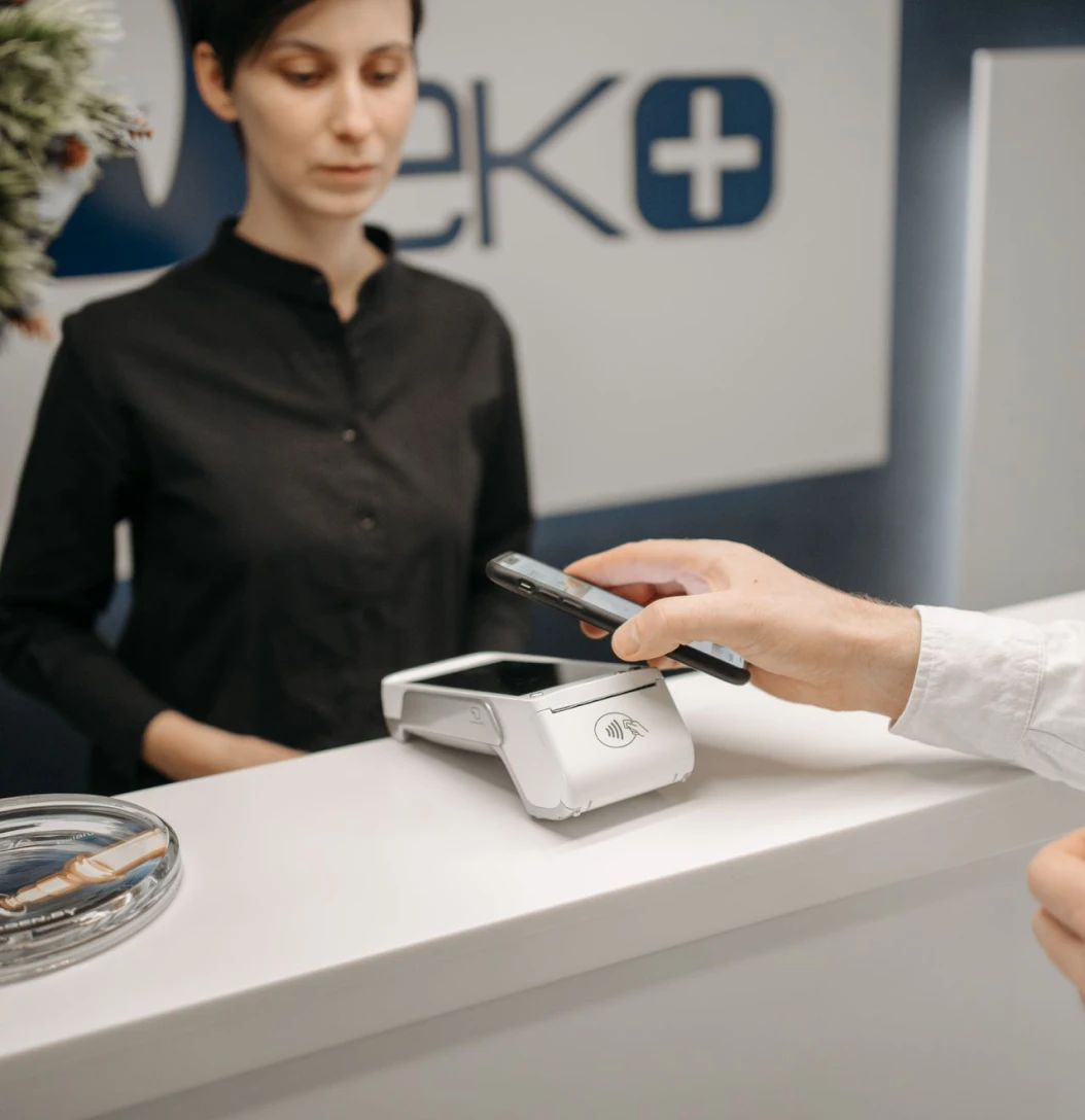 Customer making a contactless payment using a smartphone at a payment terminal