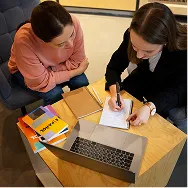 Two professionals planning software requirements with a laptop