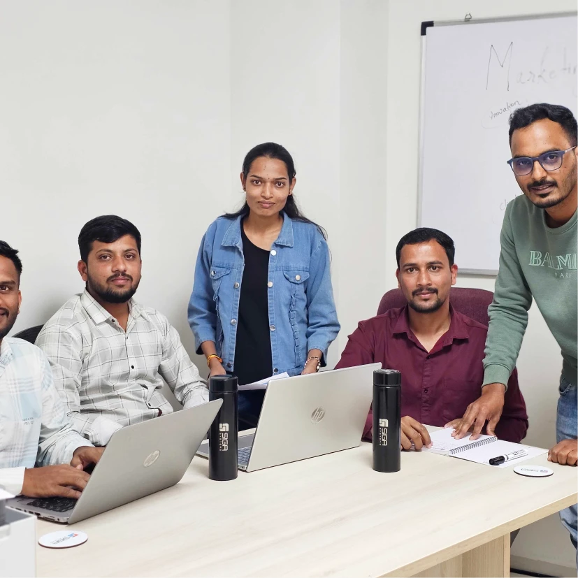 SiGa Systems team collaborating around laptops in the office